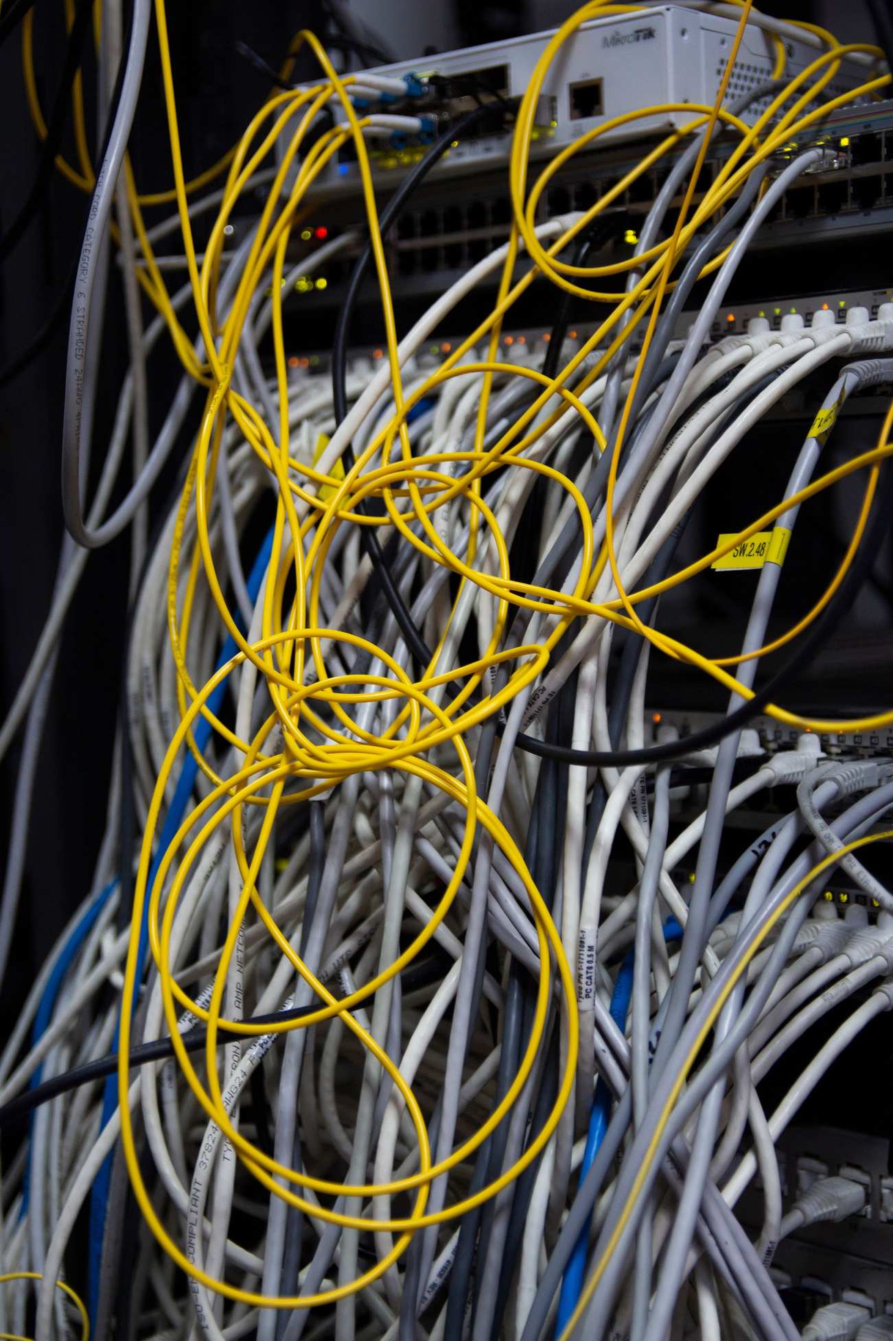 Close view of server rack cabling and network hardware, messy bundle of network cables tangled in a server rack